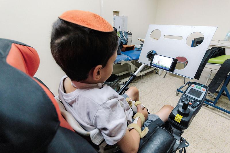 Niño discapacitado usando tecnología adaptada de Sesame para poder usar el móvil