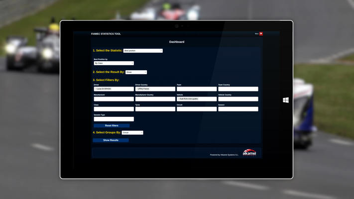 Tableta con estadíticas AlKamel con fondo de una carrera de coches